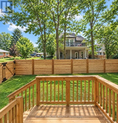 A wooden deck with a house in the background.