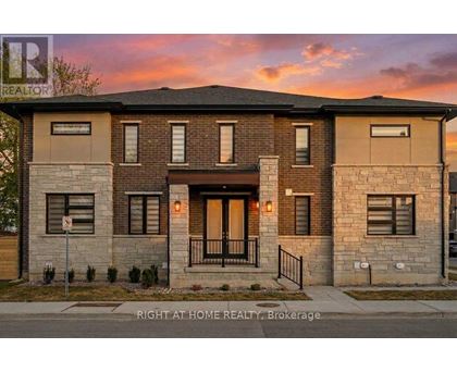 A modern two-story house with a front porch and a garage door.