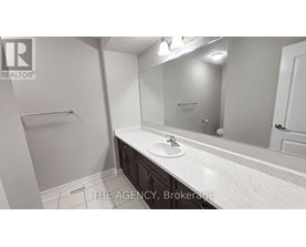 A bathroom with a sink, mirror, and towel rack.