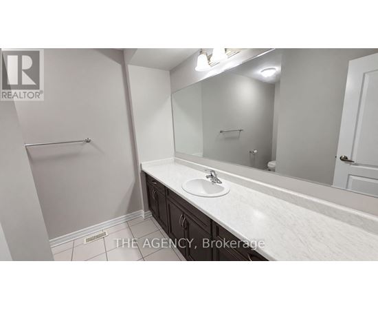 A bathroom with a sink, mirror, and towel rack.