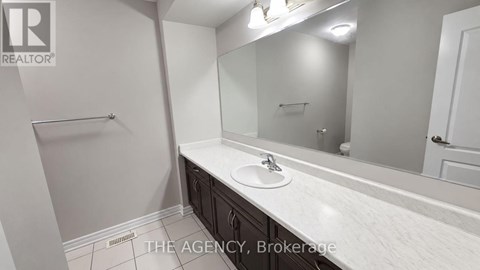 A bathroom with a sink, mirror, and towel rack.
