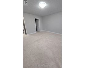 A room with a carpeted floor and a door.