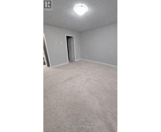 A room with a carpeted floor and a door.