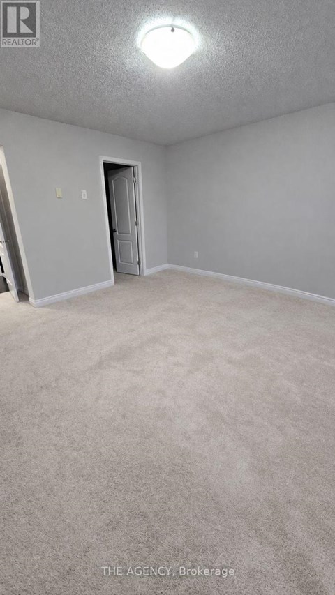 A room with a carpeted floor and a door.