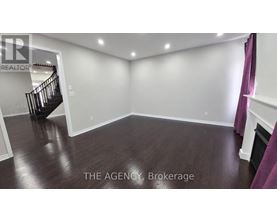A spacious room with a staircase and wooden flooring.