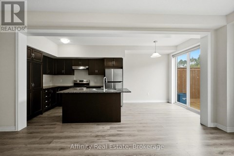 A spacious kitchen with dark brown cabinets and a large island.
