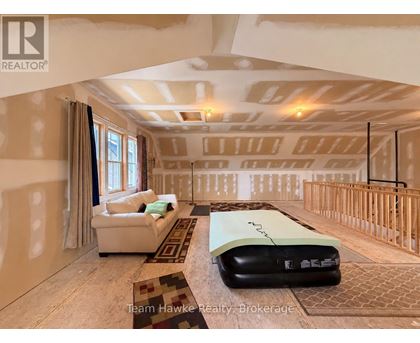 A room with a white sofa and a black mattress on the floor.