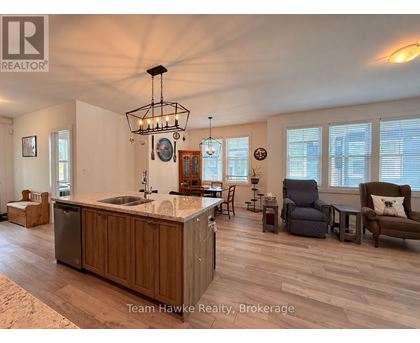 A spacious kitchen with wooden cabinets and a marble countertop.
