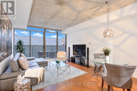 A living room with a couch, chairs, and a glass table.