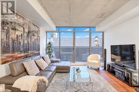 A living room with a large couch and a painting on the wall.