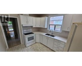 A kitchen with white cabinets and appliances is for sale.