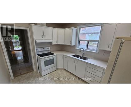 A kitchen with white cabinets and appliances is for sale.