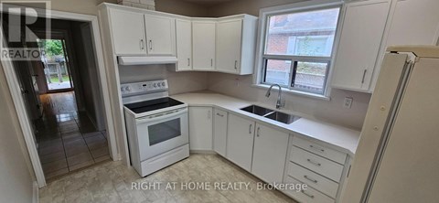 A kitchen with white cabinets and appliances is for sale.