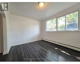 A room with a large window and wooden flooring.