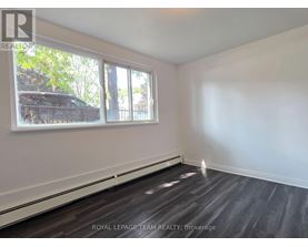 A room with a window and a wooden floor.