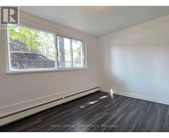 A room with a window and a wooden floor.