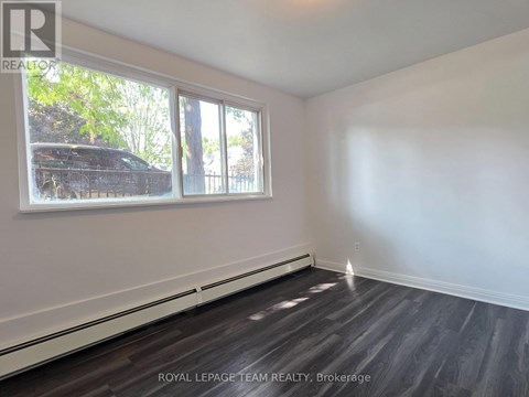 A room with a window and a wooden floor.