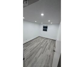 A room with wooden flooring and a window.