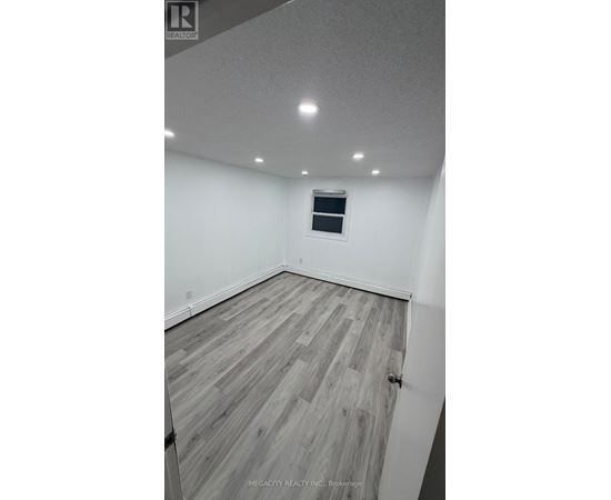 A room with wooden flooring and a window.