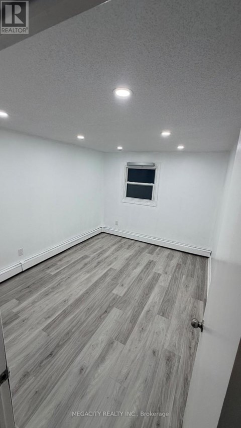 A room with wooden flooring and a window.