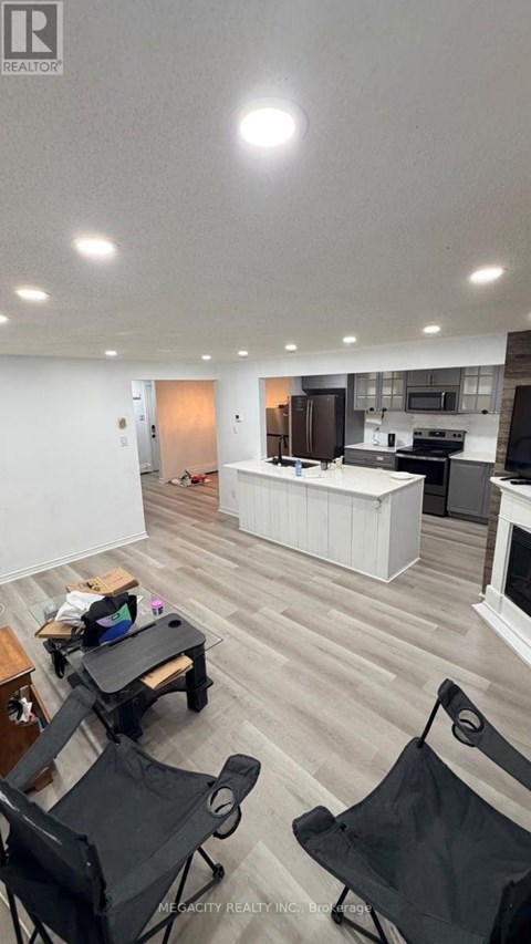 A living room with a kitchen in the background and a dining table with chairs in the foreground.