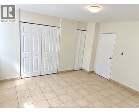 A room with white doors and tiled flooring.