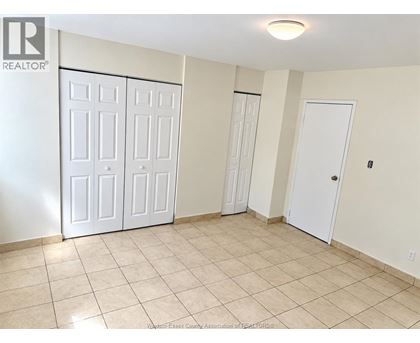 A room with white doors and tiled flooring.