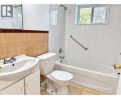A bathroom with a toilet, sink, and bathtub.