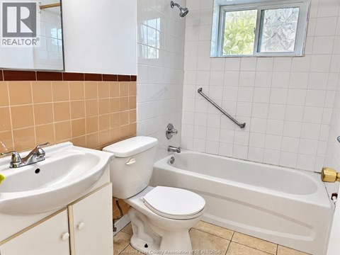 A bathroom with a toilet, sink, and bathtub.