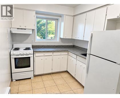A kitchen with white appliances and cabinets.