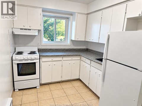 A kitchen with white appliances and cabinets.