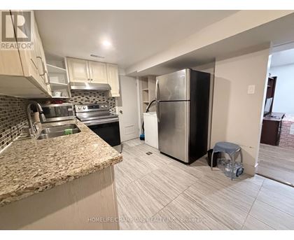 A kitchen with a granite counter top and a refrigerator.