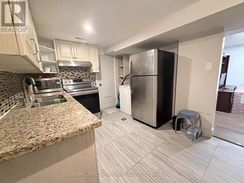 A kitchen with a granite counter top and a refrigerator.