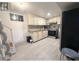 A kitchen with white cabinets and a black refrigerator.