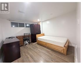 A bedroom with a bed, dresser, and chair.