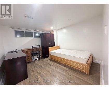 A bedroom with a bed, dresser, and chair.