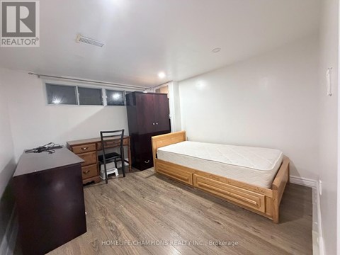 A bedroom with a bed, dresser, and chair.
