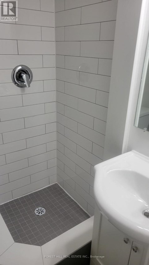A white sink in a white tiled bathroom.