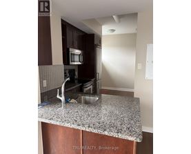A kitchen with granite countertops and wooden cabinets.