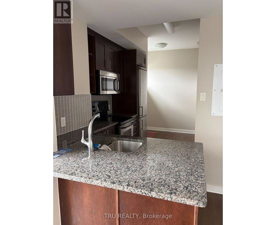 A kitchen with granite countertops and wooden cabinets.