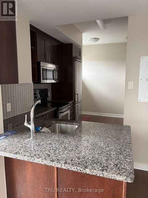 A kitchen with granite countertops and wooden cabinets.