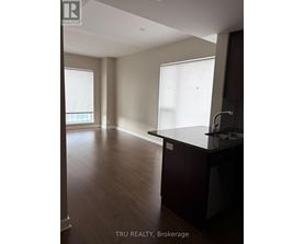 A kitchen with dark wood floors and a counter top.
