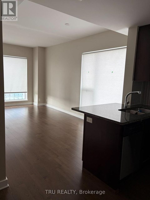 A kitchen with dark wood floors and a counter top.