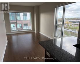 A room with a large window overlooking a parking lot.