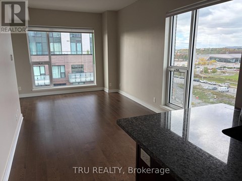 A room with a large window overlooking a parking lot.