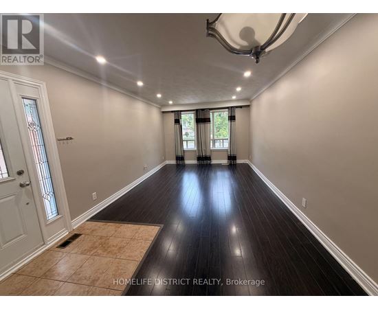 A spacious room with wooden floors and a large window.