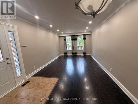A spacious room with wooden floors and a large window.