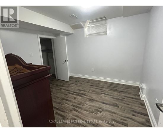 A room with a wooden floor and a white wall.