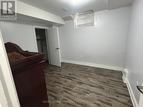 A room with a wooden floor and a white wall.