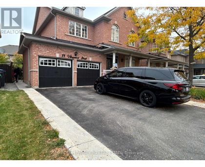 A black SUV is parked in front of a brick house with a garage.